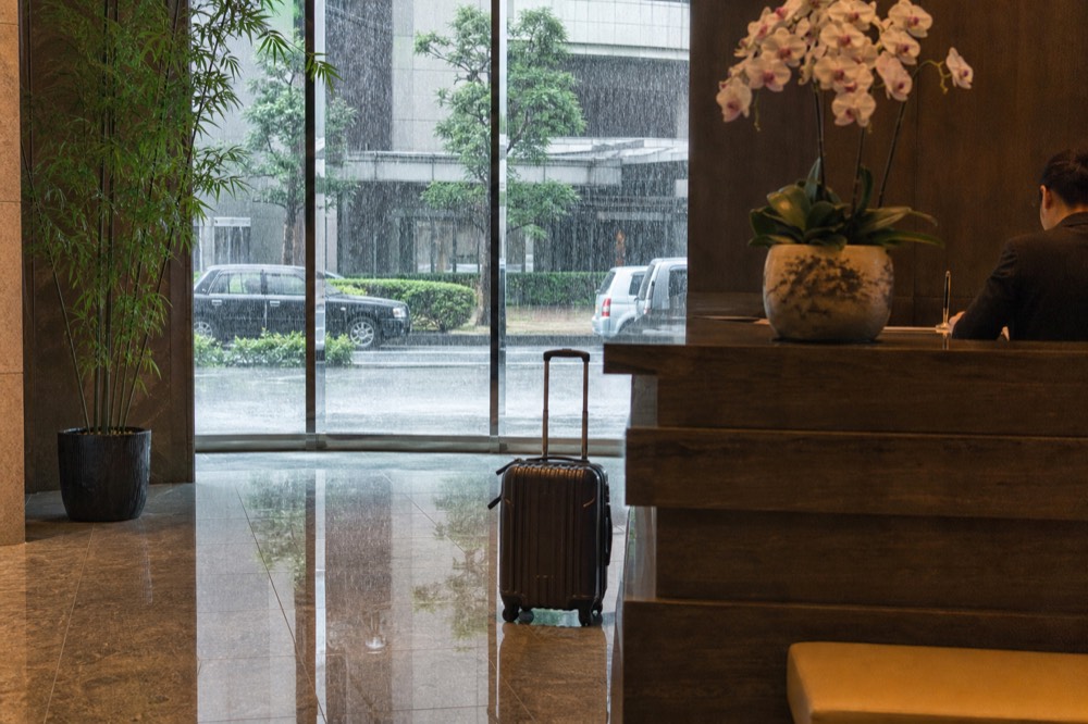 Reception desk of a modern Osaka hotel with city light through the window