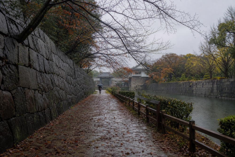 Stone wall and trees beside the castle moat in the park