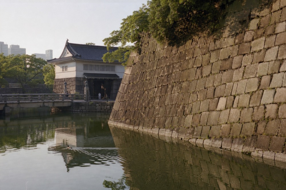 Massive fitted granite stones of the castle wall rising above the water of the inner moat