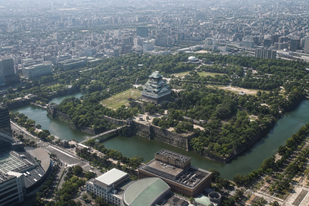 Aerial view of Osaka Castle surrounded by moats and green parkland