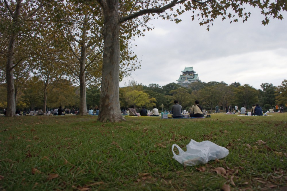 Osaka Castle park with the tower in the distance and people walking on the lawn