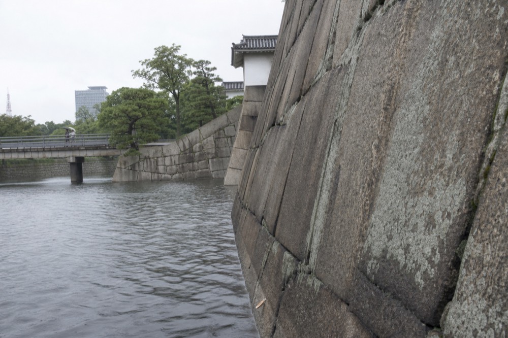 Massive fitted granite blocks of an Osaka Castle stone wall above the water of the inner moat