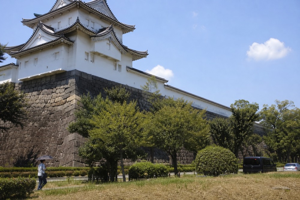 Sunlight glaring off the white walls of the Osaka Castle Main Tower in high summer