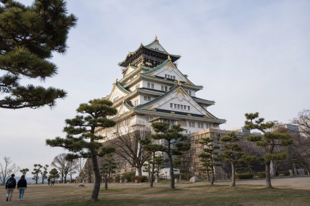 The Osaka Castle Main Tower seen from the park below with its white walls and green roof