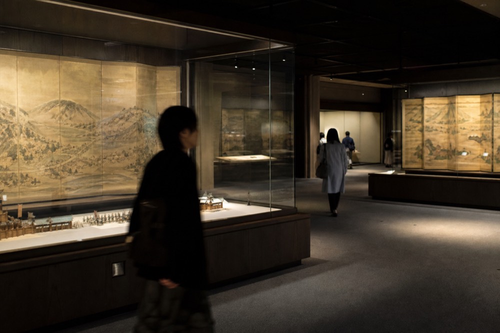 Interior exhibition hall of the castle museum with display cases and dim lighting