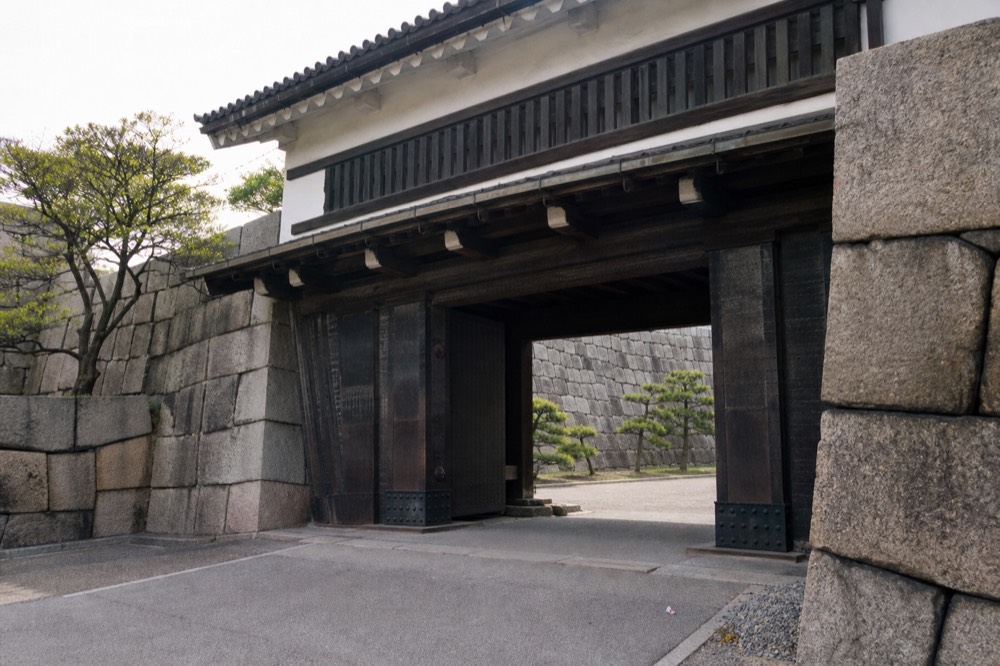 A quiet stone gateway inside Osaka Castle Park with empty path