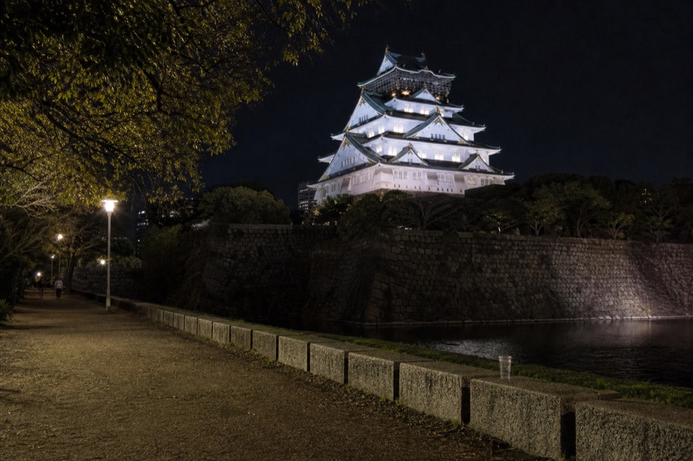 The floodlit Main Tower seen at night from the free paths beside the inner moat