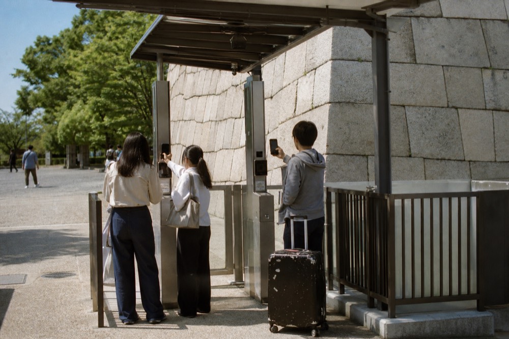Visitors with a smartphone pass scanning into the Main Tower ticket gate
