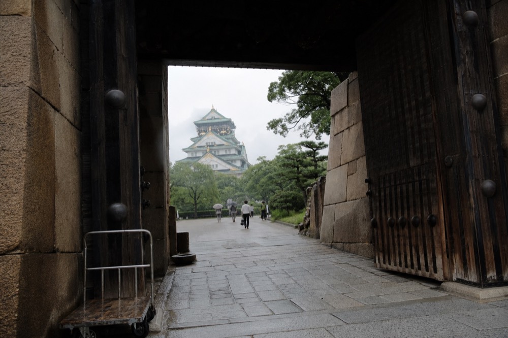 A stone gateway leading toward the castle tower
