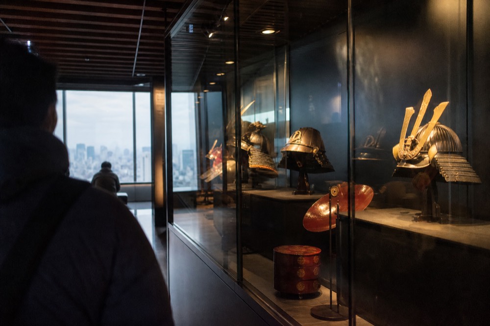 A dimly lit museum gallery inside the tower with glass display cases of historical artefacts