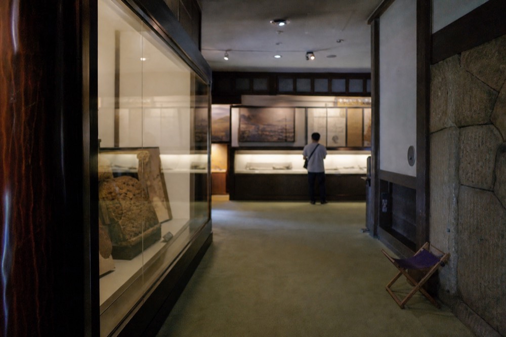 A museum exhibition room with wall panels and display cases lit for a special show