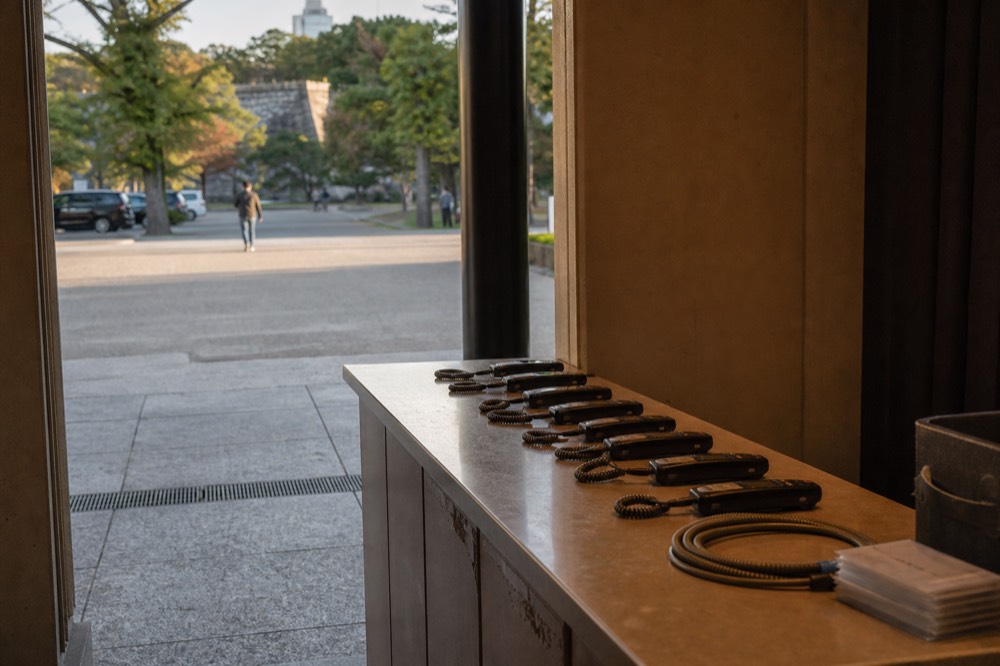 A museum information counter with audio guide handsets arranged on the desk