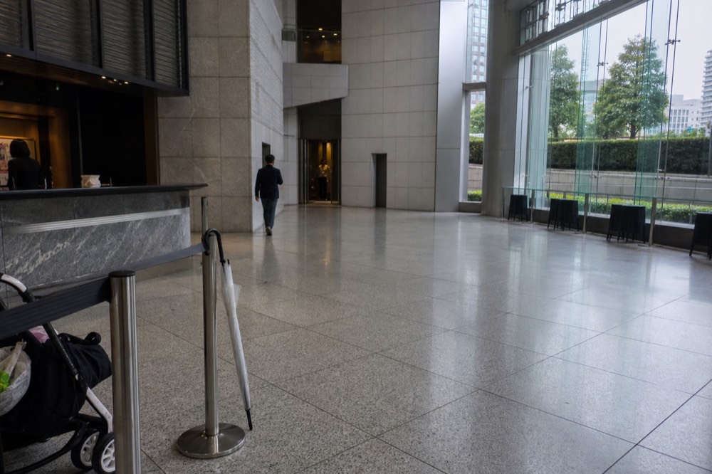 Inside the Osaka Castle Main Tower entrance hall with information counters and a sign pointing to the elevator