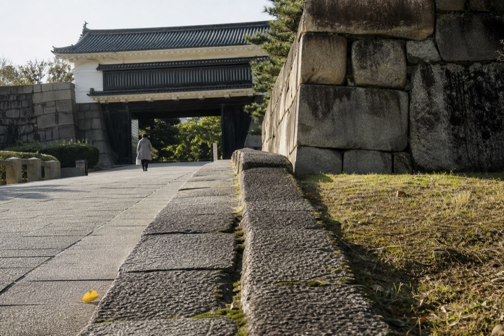 From Tanimachi 4-chome, the Otemon path runs comparatively flat into the park, a weathered granite wall lining much of the walk.