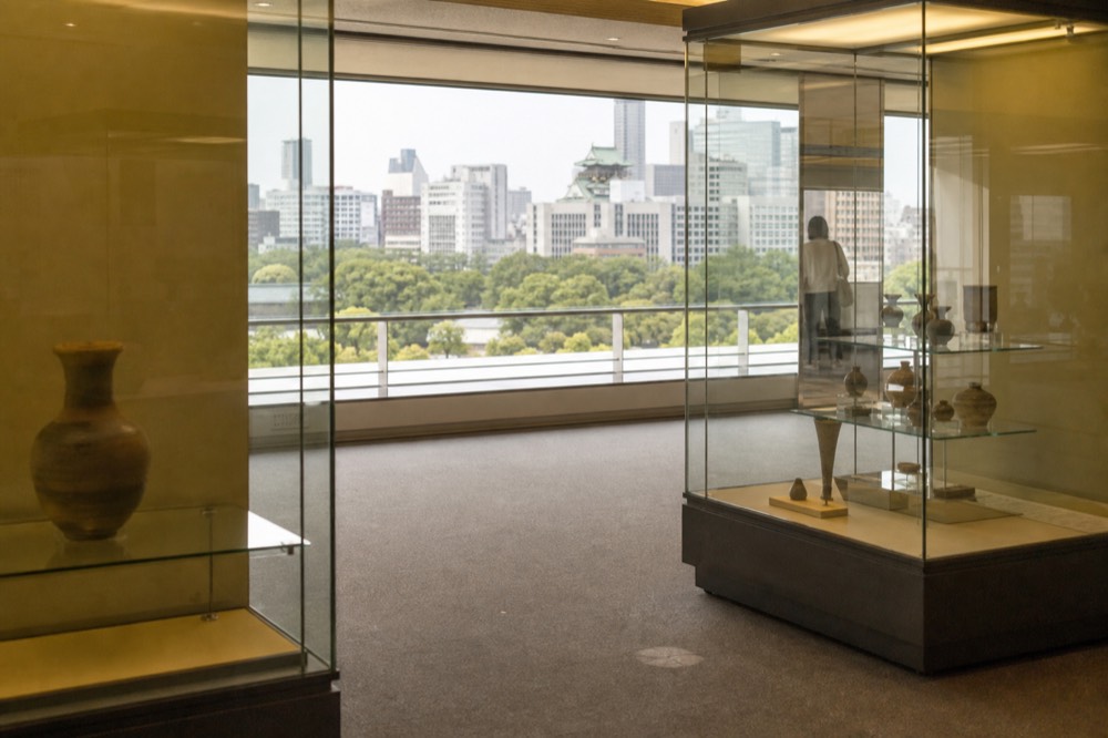 Modern museum building interior with exhibit cases and soft lighting on a upper floor